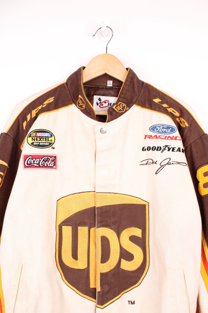 Vintage Dale Jarrett UPS NASCAR jacket by Chase Authentics in brown and orange. Features embroidered sponsor badges all over.  