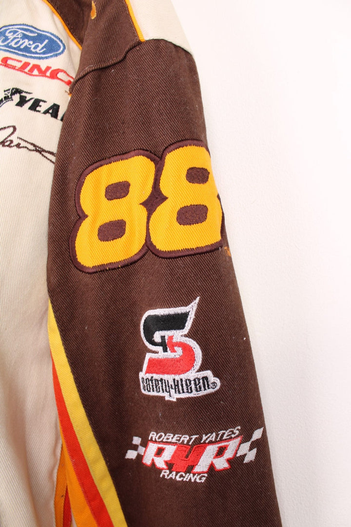 Vintage Dale Jarrett UPS NASCAR jacket by Chase Authentics in brown and orange. Features embroidered sponsor badges all over.  