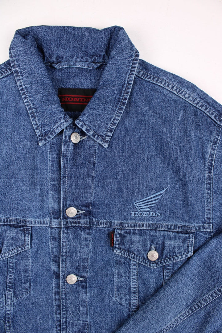 Vintage Honda denim jacket in blue, with multiple pockets, button closure, and the Honda logo embroidered on the chest and back.