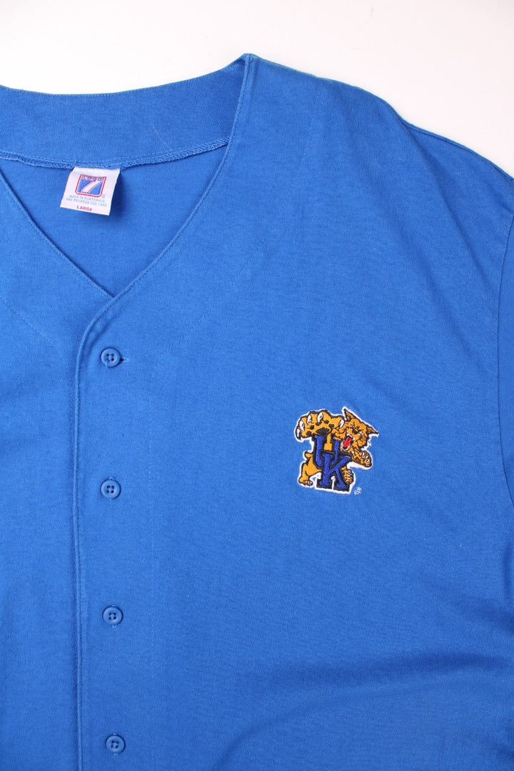 Vintage Logo 7 University of Kentucky Wildcats Training Top in blue with button closure, an embroidered wolf emblem and the initials 'U.K.', and a Logo 7 patch on the lower left.