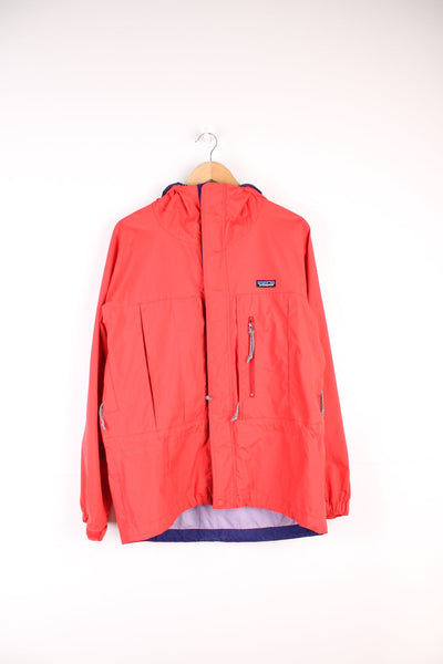 Red Patagonia hooded rain jacket with embroidered logo on the chest and multiple pockets.