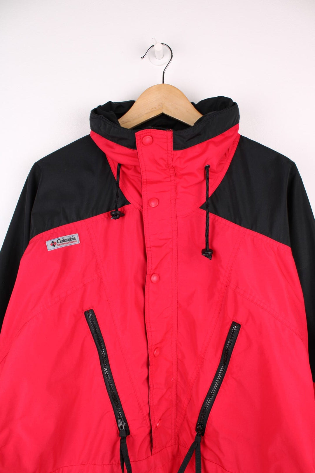 Columbia red and black zip through outdoor jacket with elasticated hem and waist. Features zip away hood, multiple pockets and embroiderd logo on the chest