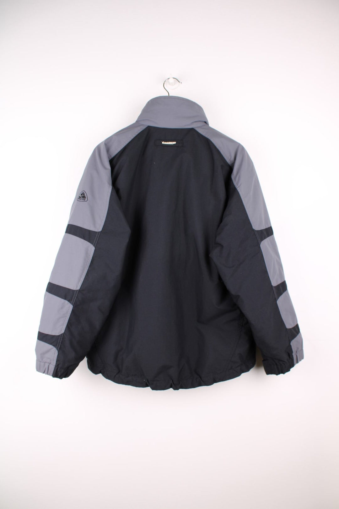 Nike ACG black and grey tech jacket. Features multiple pockets and zip in green quilted liner. 