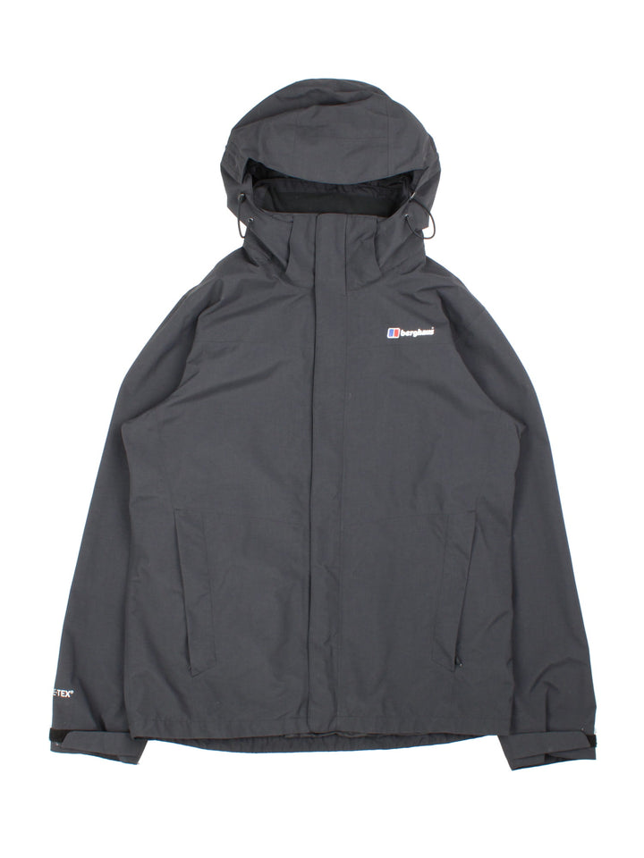 Berghaus Gortex Jacket in a black colourway. Zip double pocket on front with classic logo on chest and thin netted lining inside.