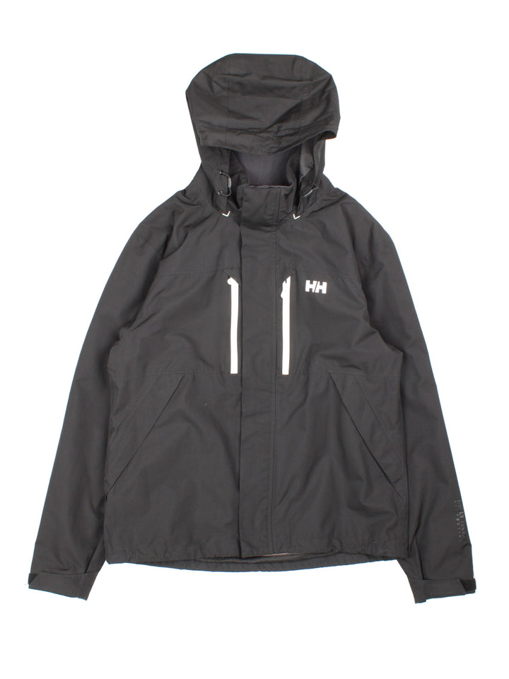 Helly Hansen Jacket in a black colourway. Multiple pockets, hooded, and has the brand logo on front and on the back under the hood.