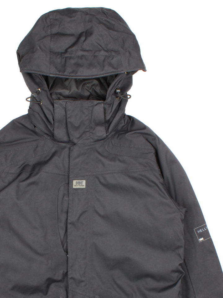 Helly Hansen Jacket in a black colourway. Multiple pockets on front, sides and inside. Drawstring hood and has the small logo embroidered on the sleeve and on the front.