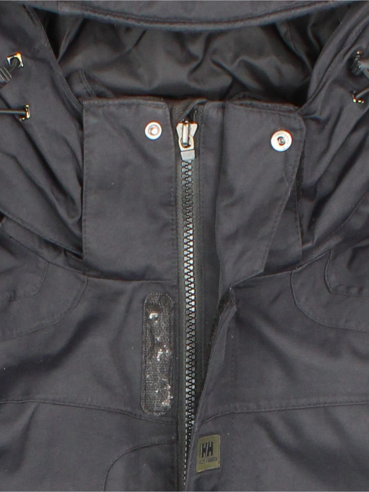 Helly Hansen Jacket in a black colourway. Multiple pockets on front, sides and inside. Drawstring hood and has the small logo embroidered on the sleeve and on the front.