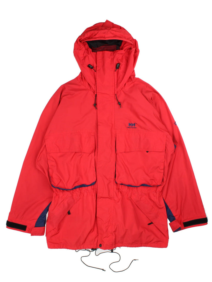 Vintage Helly Hansen Jacket in a red/blue colourway. Zip and velcro fastening, hood, multiple pockets and mesh lining. Embroidered branding on front/sleeve.