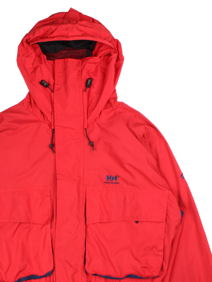 Vintage Helly Hansen Jacket in a red/blue colourway. Zip and velcro fastening, hood, multiple pockets and mesh lining. Embroidered branding on front/sleeve.