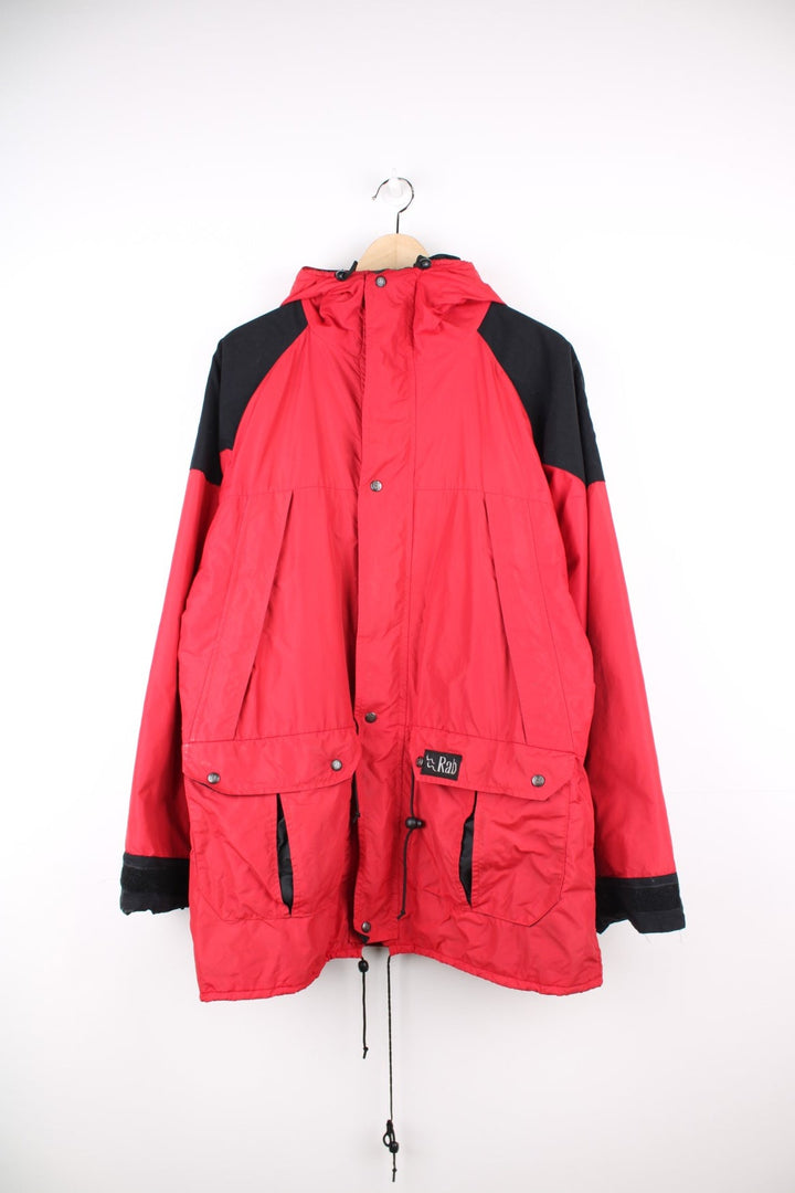 Vintage Rab red and black hooded rain jacket with multiple pockets and embroidered logo.