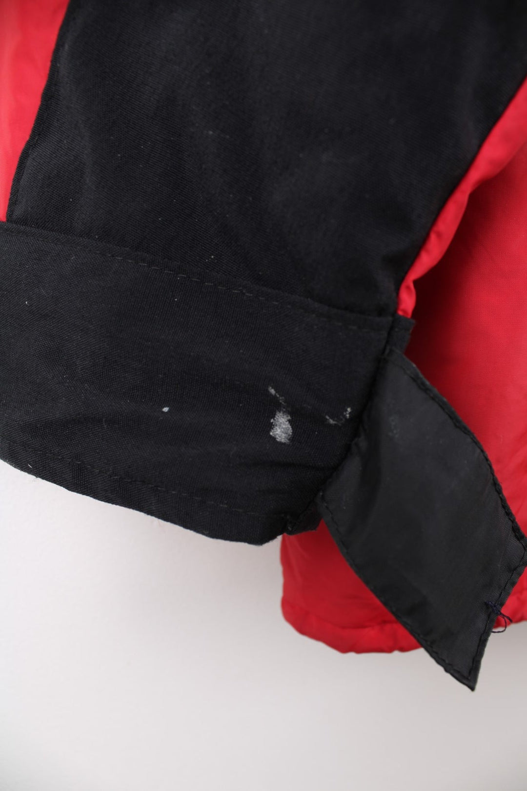 Vintage Rab red and black hooded rain jacket with multiple pockets and embroidered logo.