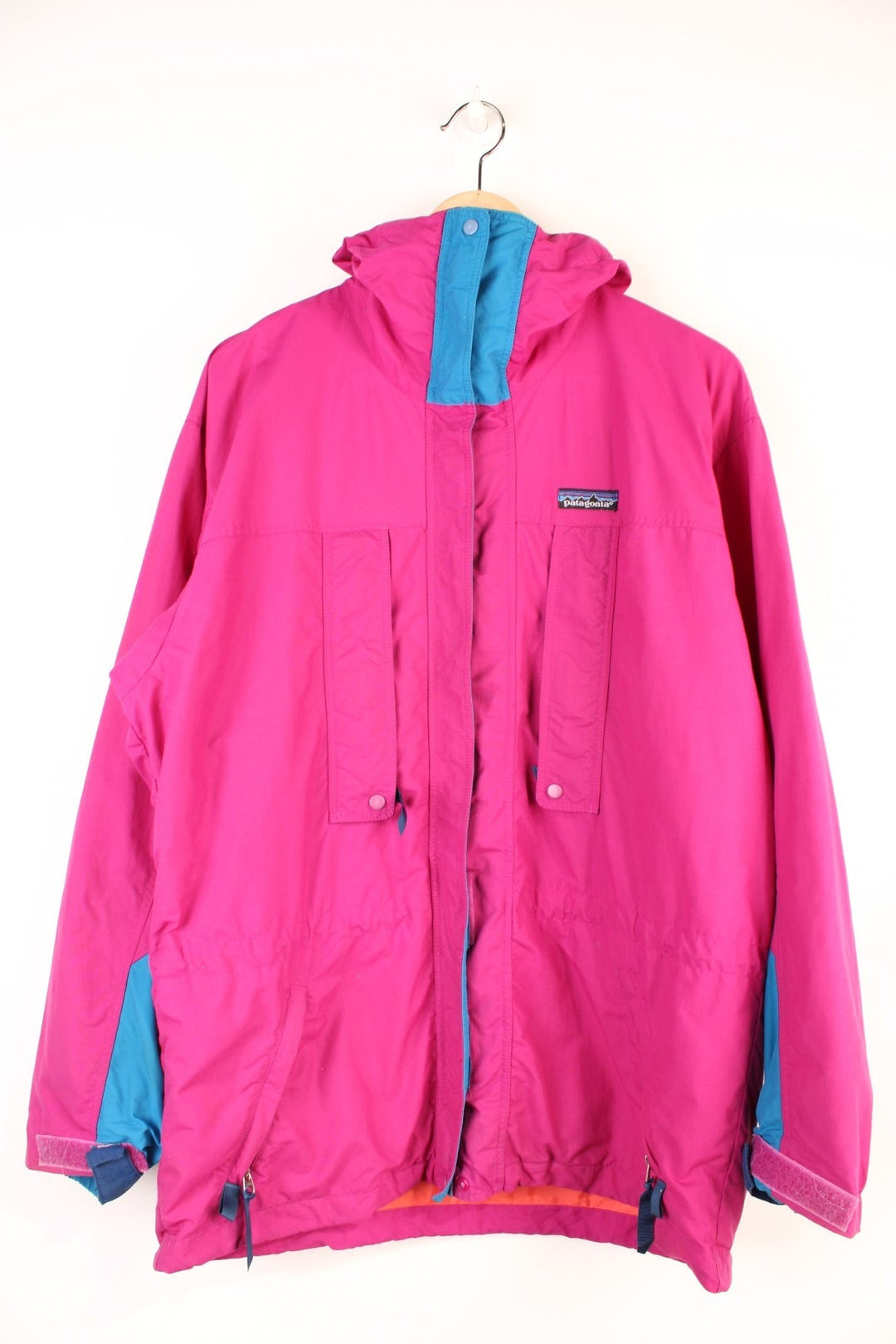 Vintage Patagonia Jacket in a pink and blue colourway, zip up with multiple pockets, hooded and has the logo embroiderd on the front. 