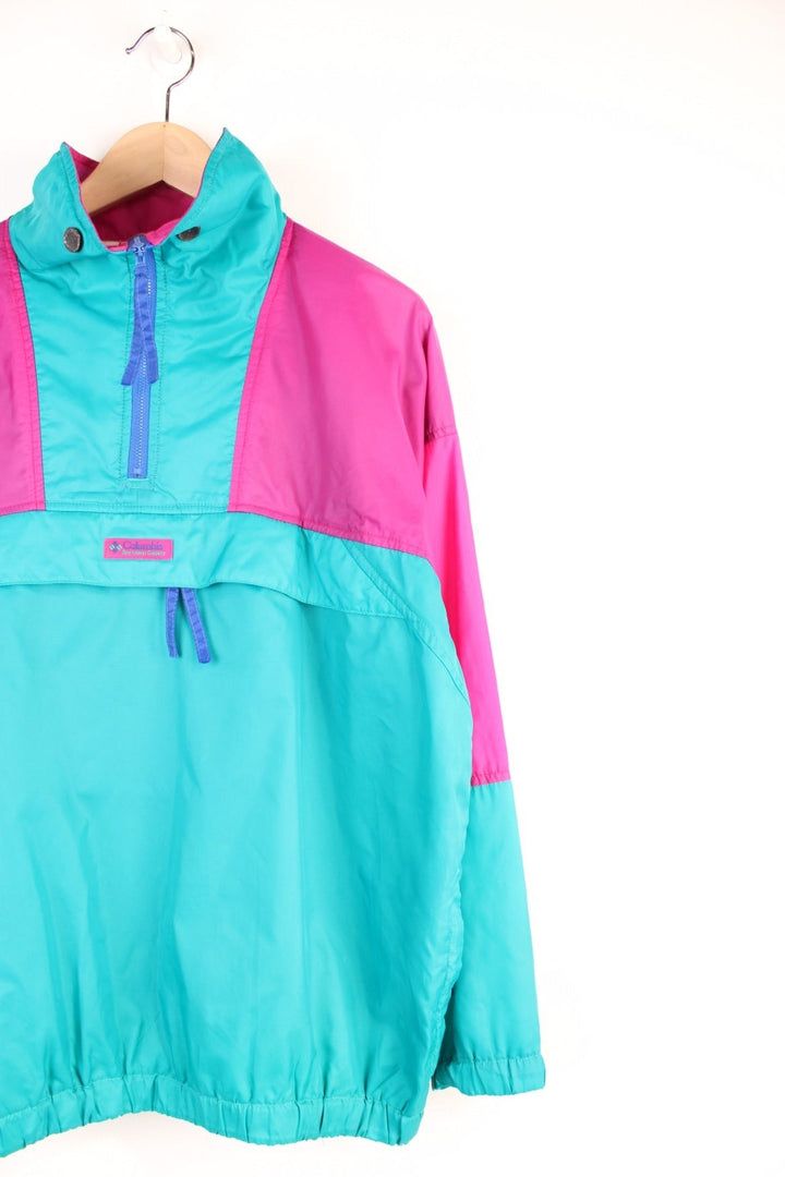 Columbia Lightweight Anorak Jacket in a pink and turquoise colourway, quarter zip up, pouch pockets, and has the logo embroidered on the front. 