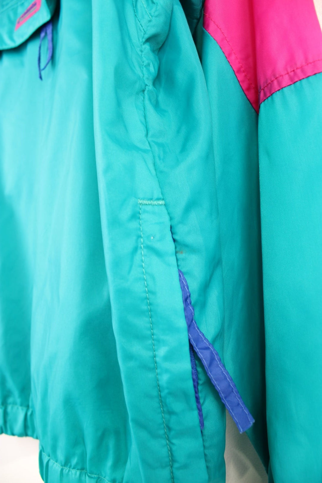 Columbia Lightweight Anorak Jacket in a pink and turquoise colourway, quarter zip up, pouch pockets, and has the logo embroidered on the front. 