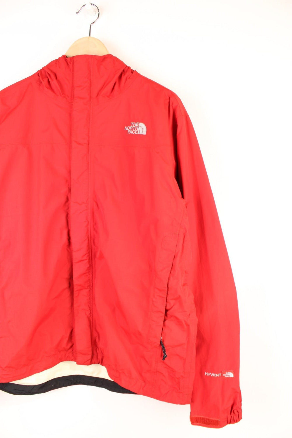 The North Face Hyvent Jacket in a red colourway, zip up with side pockets, hooded, and has the logo embroidered on the front and back. 