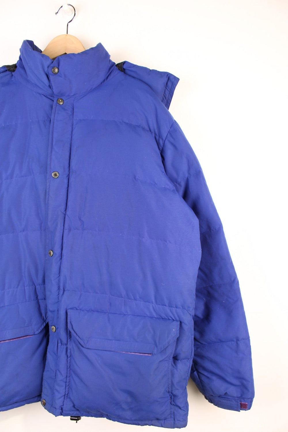 Vintage 90's The North Face Baltoro Down Puffer Coat in a blue colourway, zip up with side pockets, insulated, has a detachable hood and the logo embroidered on the left sleeve. 