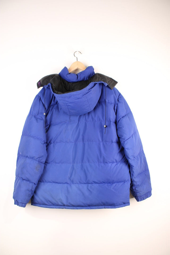 Vintage 90's The North Face Baltoro Down Puffer Coat in a blue colourway, zip up with side pockets, insulated, has a detachable hood and the logo embroidered on the left sleeve. 