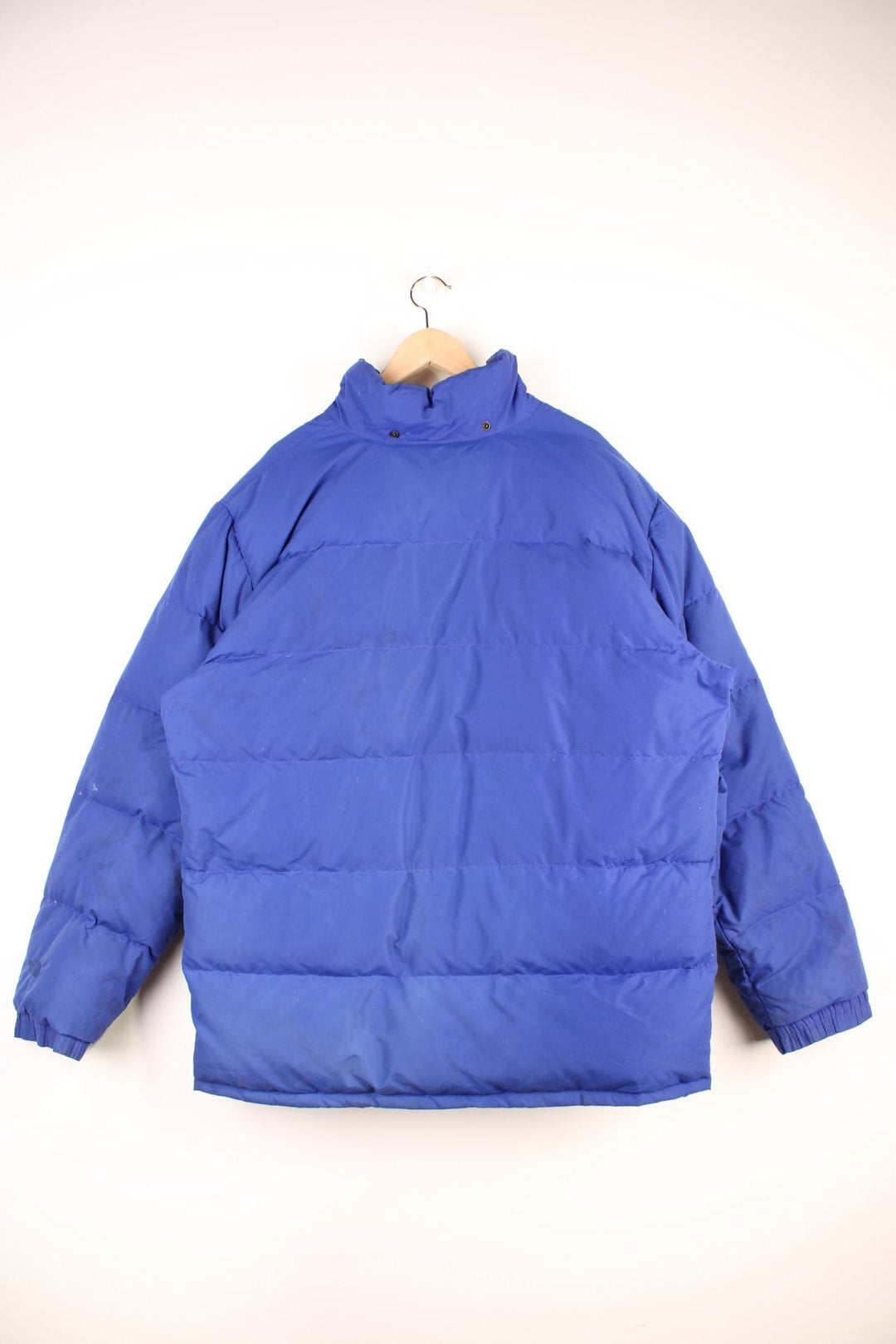 Vintage 90's The North Face Baltoro Down Puffer Coat in a blue colourway, zip up with side pockets, insulated, has a detachable hood and the logo embroidered on the left sleeve. 