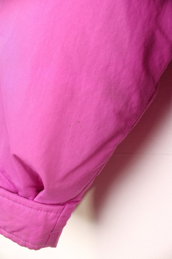 The North Face Down Parka Coat in a pink colourway, zip and button up, has a detachable hood, multiple pockets, insulated, and has the logo embroidered on the left sleeve. 