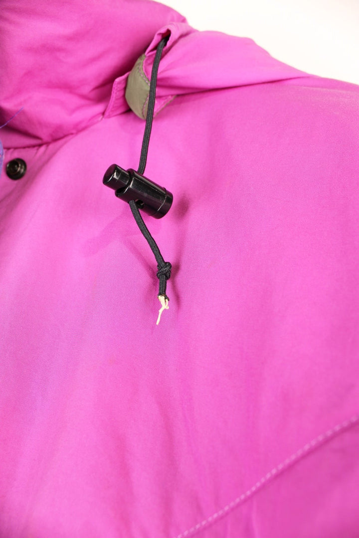 The North Face Down Parka Coat in a pink colourway, zip and button up, has a detachable hood, multiple pockets, insulated, and has the logo embroidered on the left sleeve. 