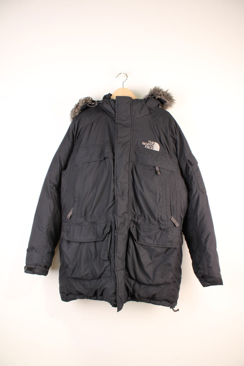 The North Face Parka Coat in a black colourway, zip up with multiple pockets, insulated, has a detachable hood with a faux fur trim, and the logo embroidered on the front and back.