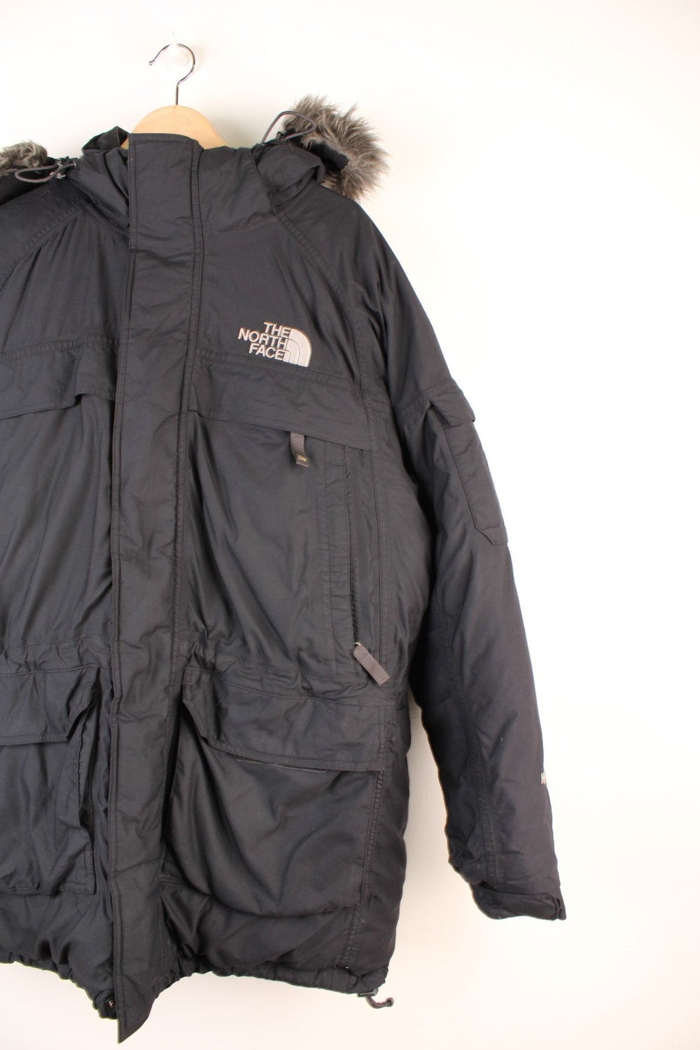 The North Face Parka Coat in a black colourway, zip up with multiple pockets, insulated, has a detachable hood with a faux fur trim, and the logo embroidered on the front and back.