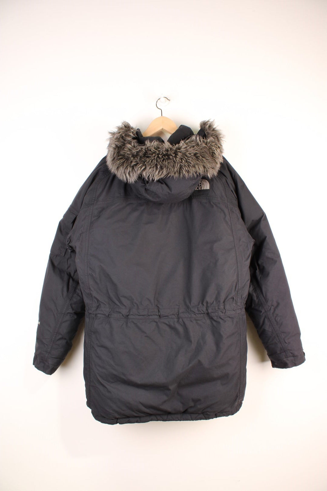 The North Face Parka Coat in a black colourway, zip up with multiple pockets, insulated, has a detachable hood with a faux fur trim, and the logo embroidered on the front and back.