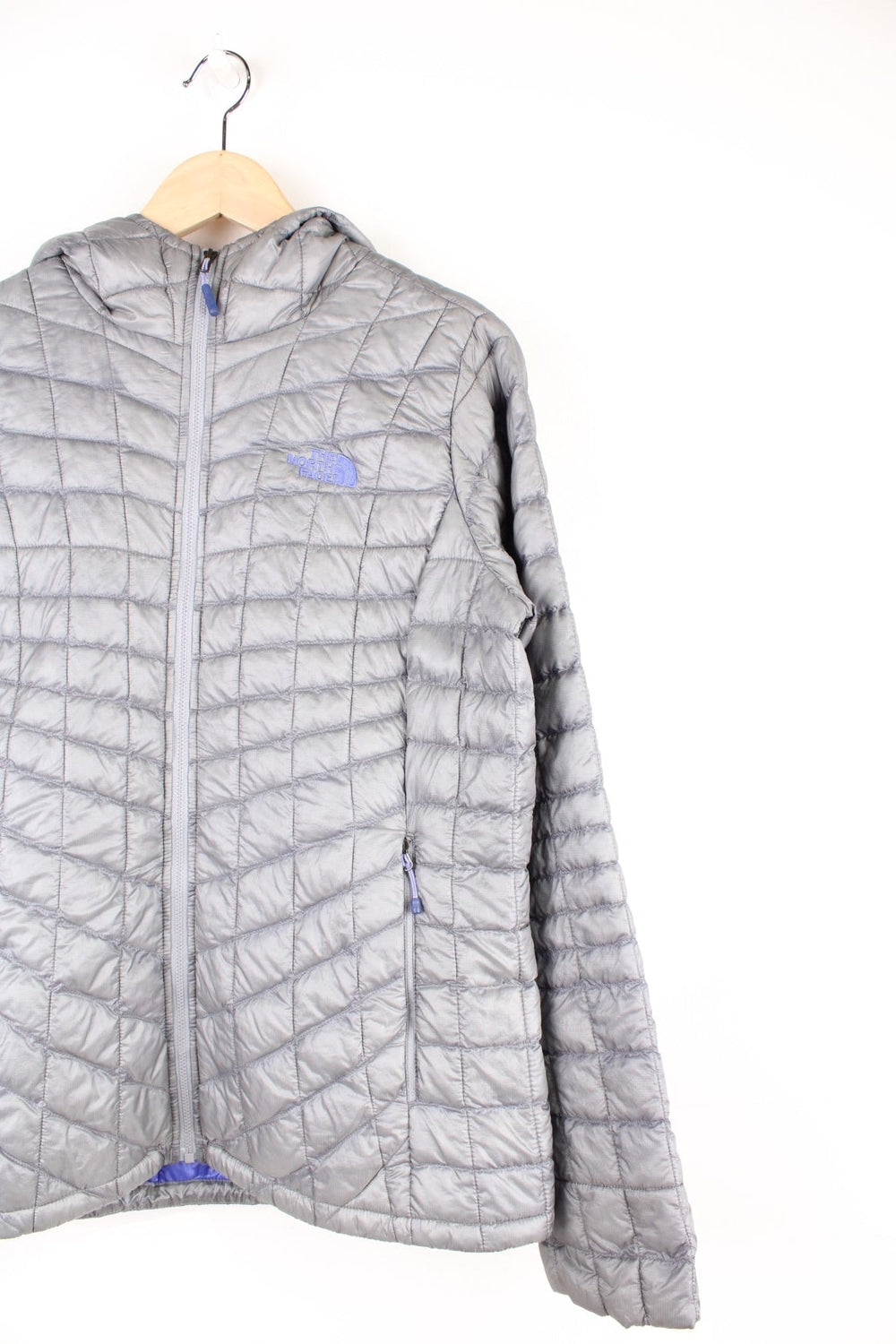 The North Face Thermoball Jacket in a grey colourway, zip up with side pockets, insulated, hooded and has the logo embroiderd on the front and back.