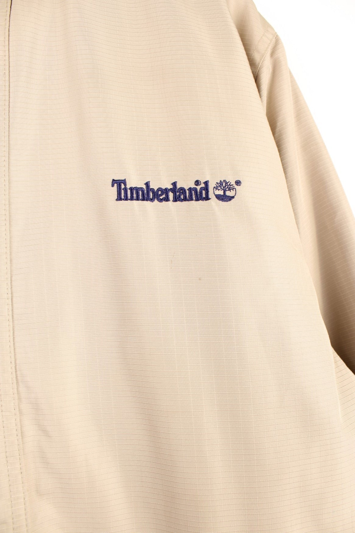 Timberland Jacket in a tanned colourway, zip and button up, side pockets, has a hideable hood, insulated with a fleece lining, and has the logo embroidered on the front and back. 