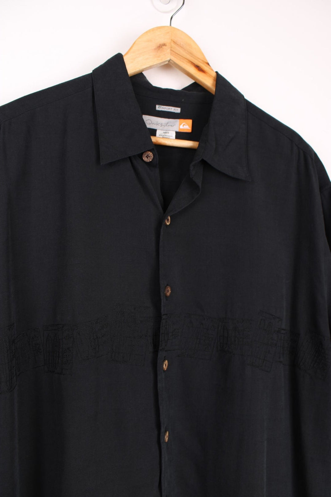 Quiksilver Surf Shirt in a black colourway with embroidered surfboard style design going across the front.