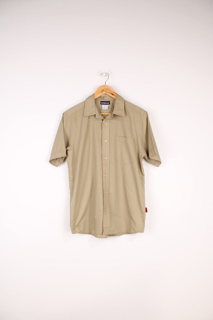 Patagonia Shirt in a tanned colourway with orange cross stitching throughout, button up with a chest pocket and has the logo emboirdered on the side.