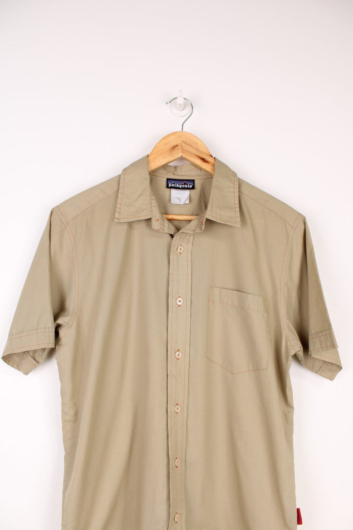 Patagonia Shirt in a tanned colourway with orange cross stitching throughout, button up with a chest pocket and has the logo emboirdered on the side.