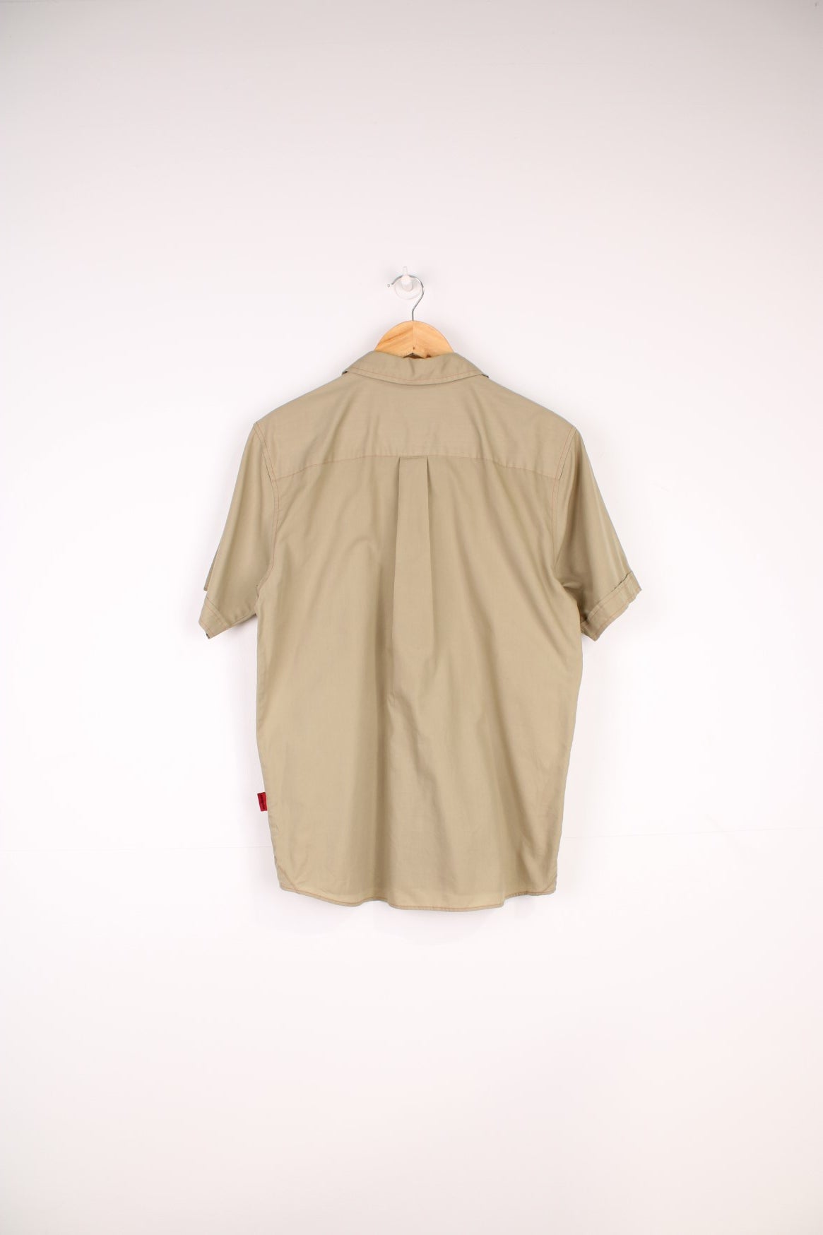 Patagonia Shirt in a tanned colourway with orange cross stitching throughout, button up with a chest pocket and has the logo emboirdered on the side.