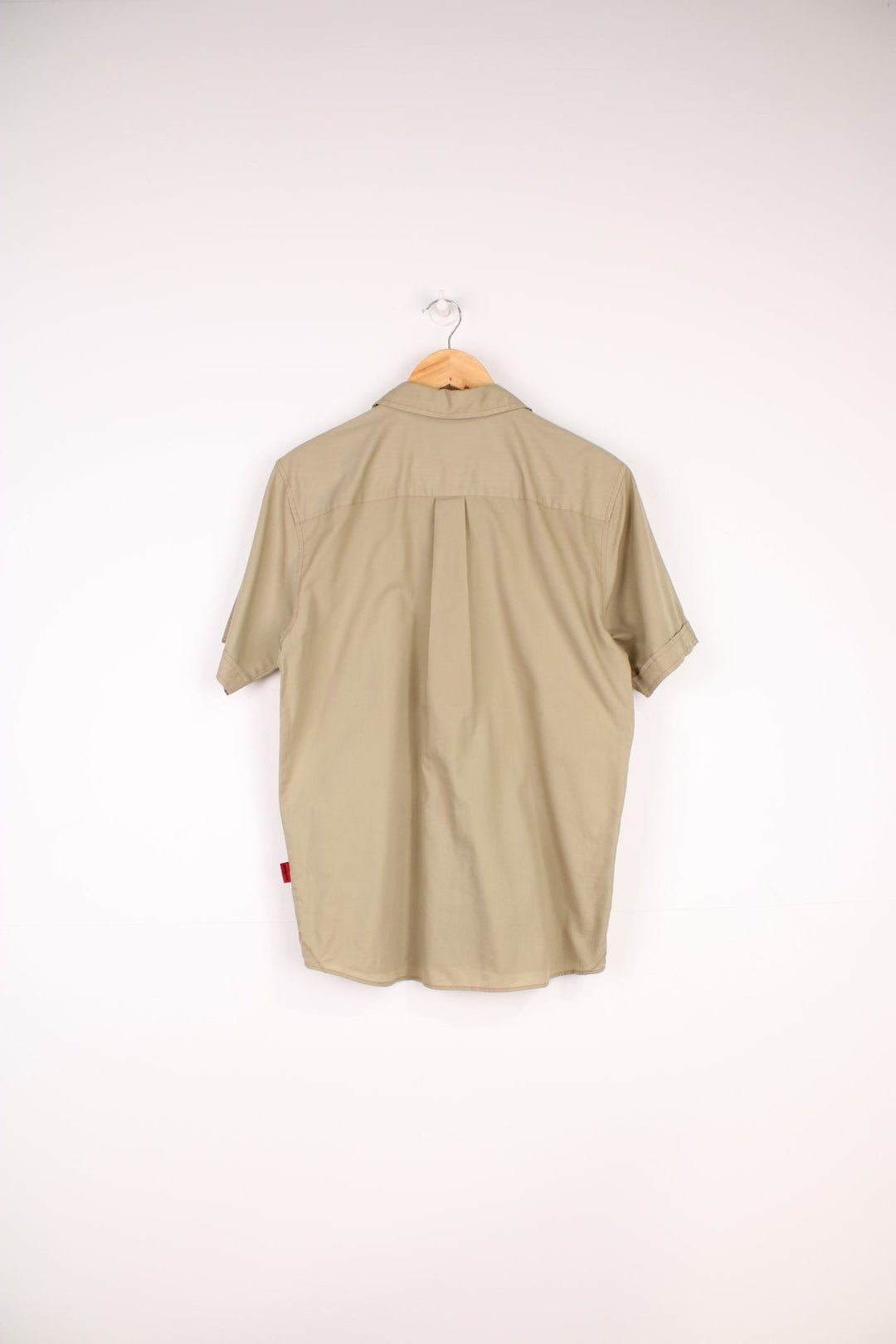 Patagonia Shirt in a tanned colourway with orange cross stitching throughout, button up with a chest pocket and has the logo emboirdered on the side.