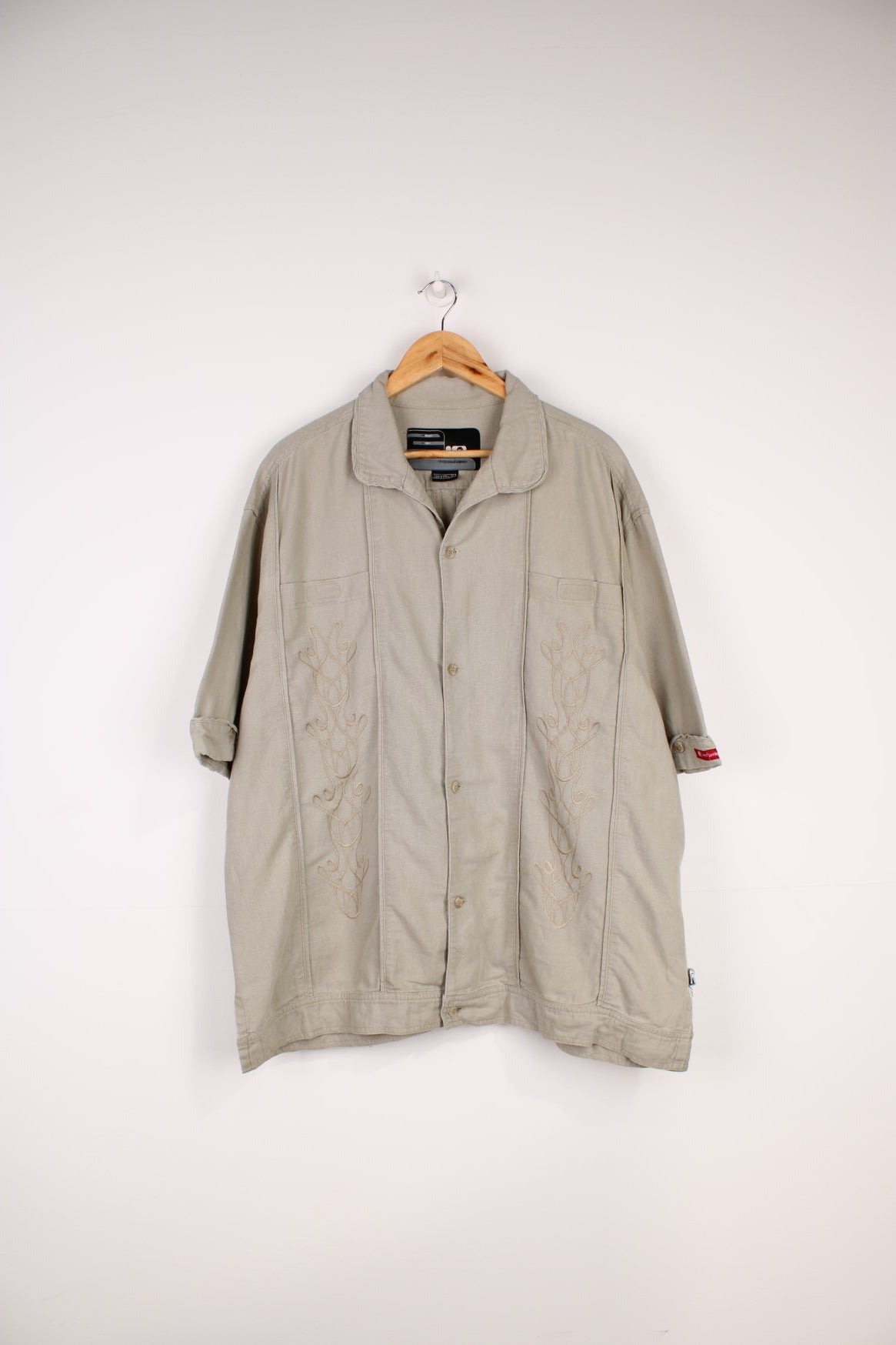 Nike Limited Edition Linen Shirt in a tanned colourway, similar style to a Cuban Guayabera shirts, button up with a camp collar, double chest pockets, and has embroidered floral pattern on the front. 