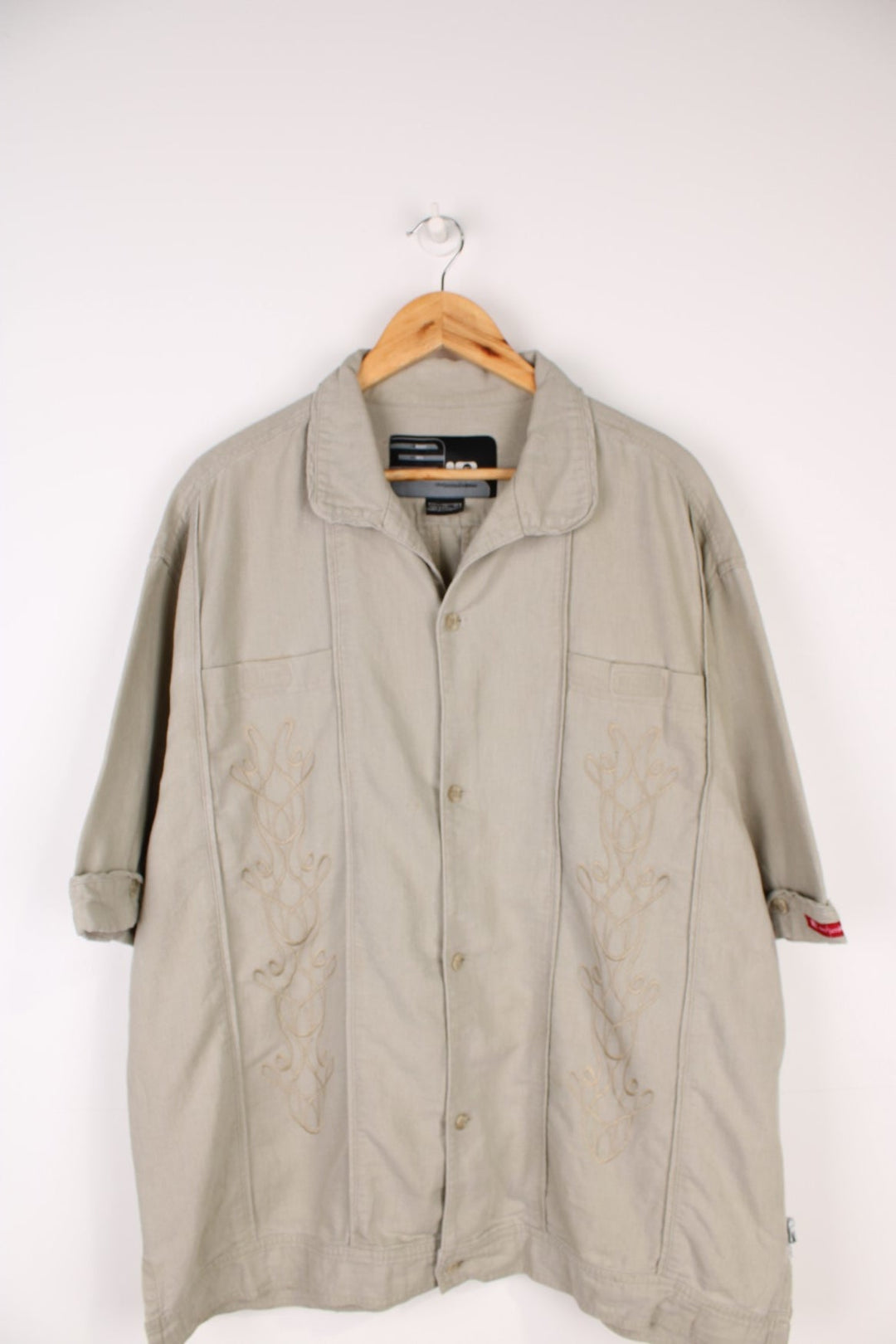 Nike Limited Edition Linen Shirt in a tanned colourway, similar style to a Cuban Guayabera shirts, button up with a camp collar, double chest pockets, and has embroidered floral pattern on the front. 