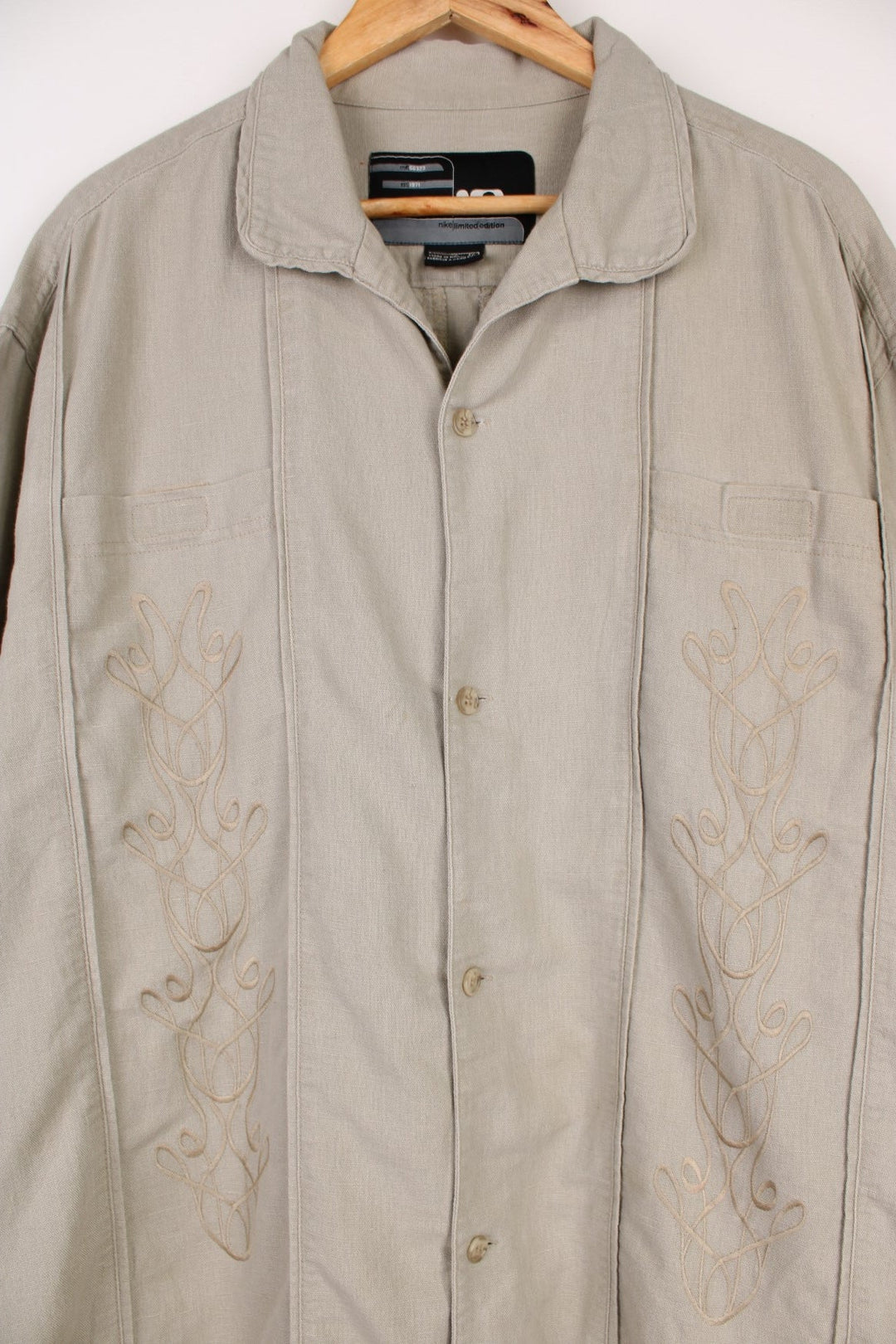 Nike Limited Edition Linen Shirt in a tanned colourway, similar style to a Cuban Guayabera shirts, button up with a camp collar, double chest pockets, and has embroidered floral pattern on the front. 