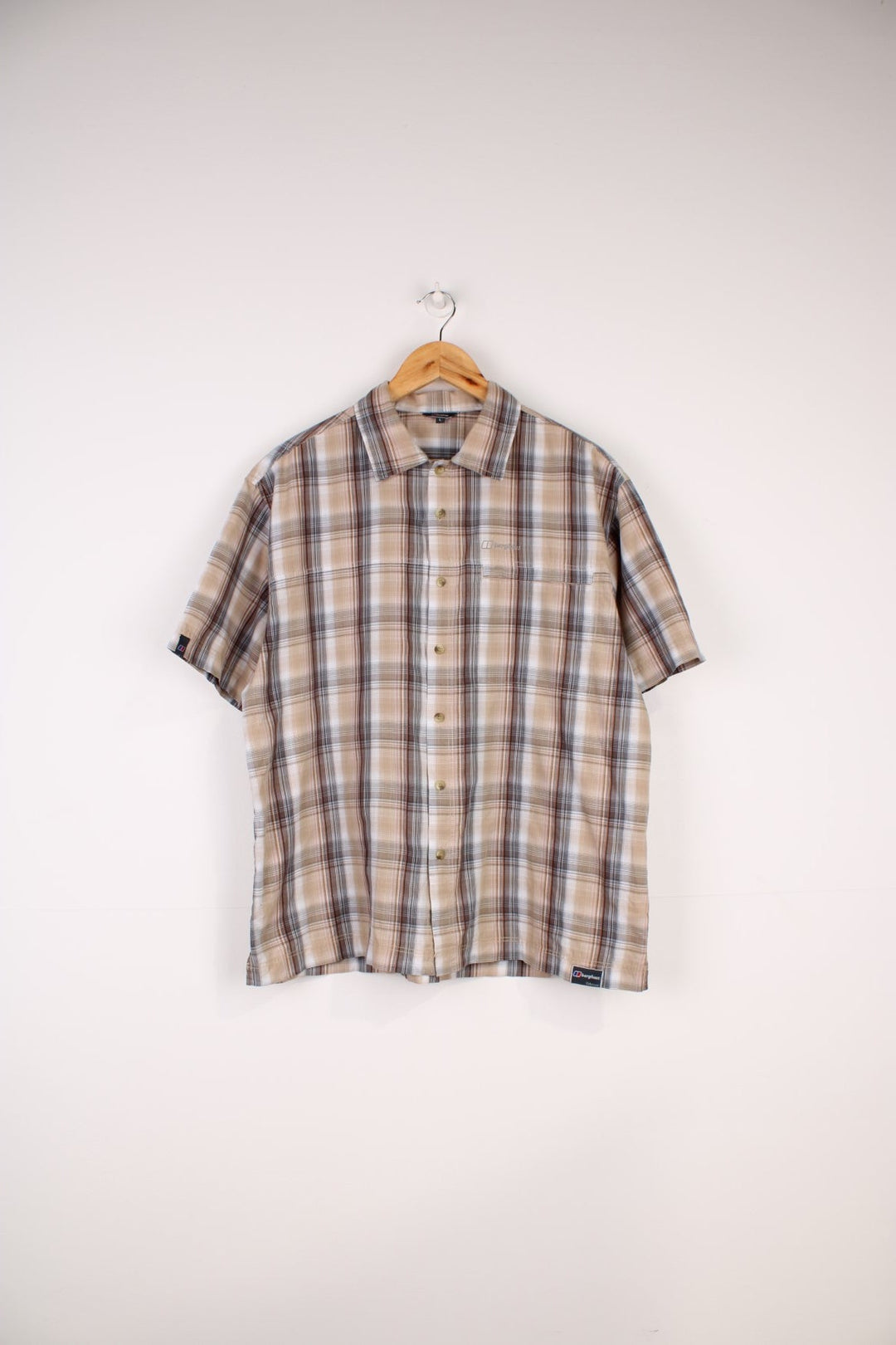 Berghaus Odyssey Shirt in a tanned brown, black and orange plaid colourway, button up shirt which has a chest pocket with the logo embroidered on it.