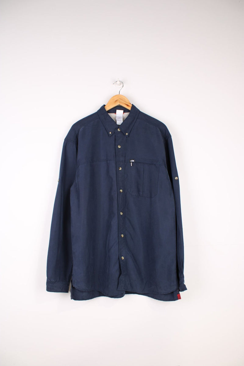 The North Face Long Sleeved Shirt in a navy blue colourway, button up and has a chest pocket with the logo embroidered on it.