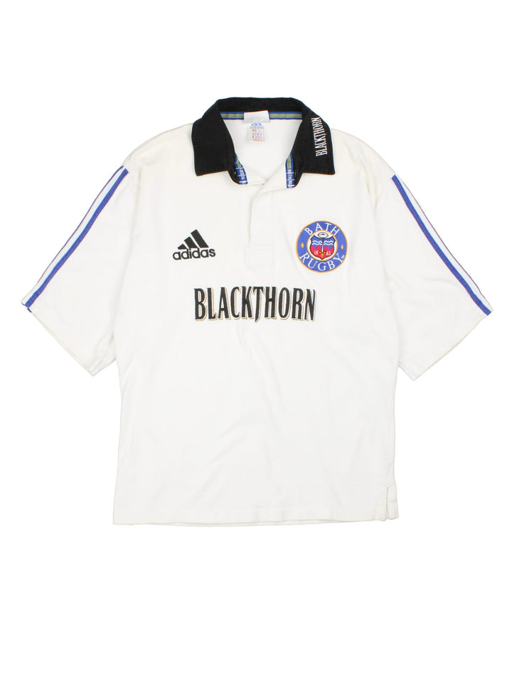 Vintage 60's Adidas Bath Rugby Shirt in a white colourway with contrast colour and stripes and has the logos embroidered on the front.