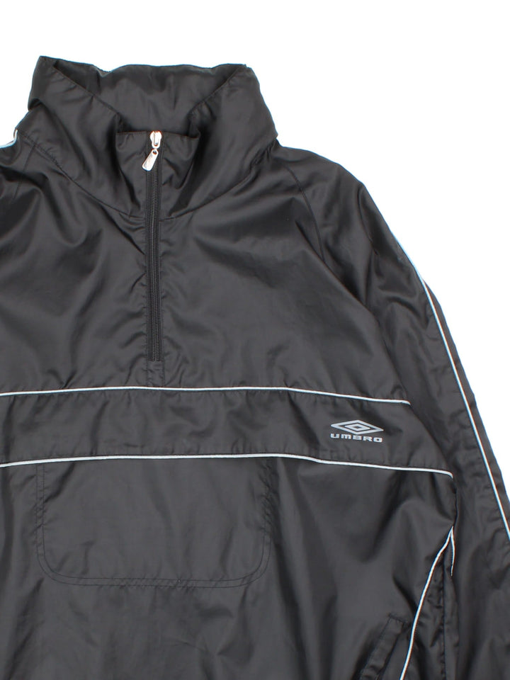 Vintage Umbro windbreaker in a black colourway, 1/4 zip fastening and has the logo printed on the front and back.