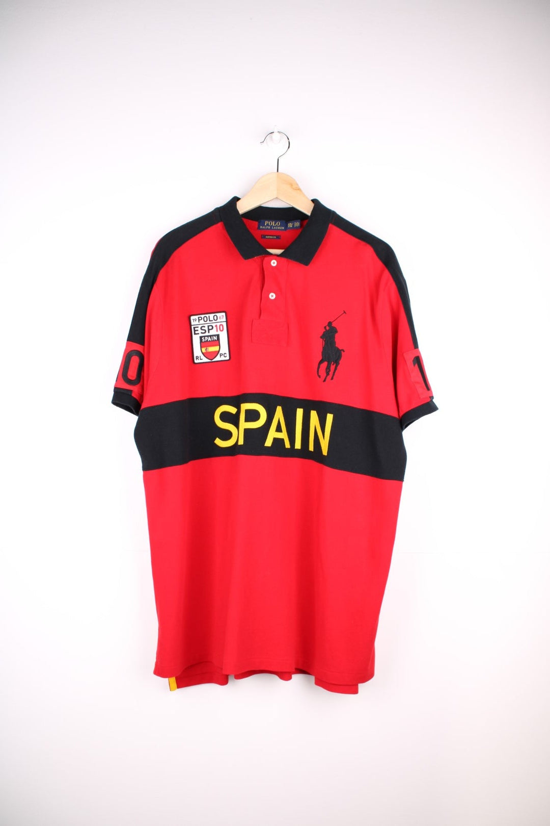 Ralph Lauren Spain polo shirt in a red colourway with black detail. Ralph Lauren logo and Spain graphic printed on front.