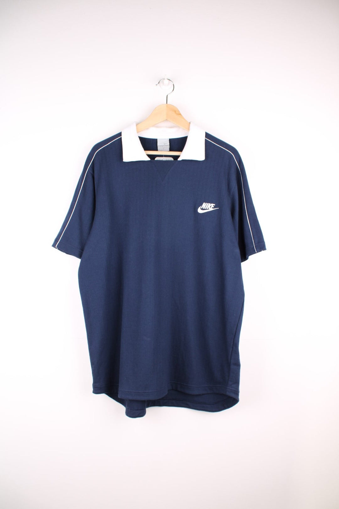 Nike polo shirt in a navy colourway with Nike logo on the front and white collar detail.