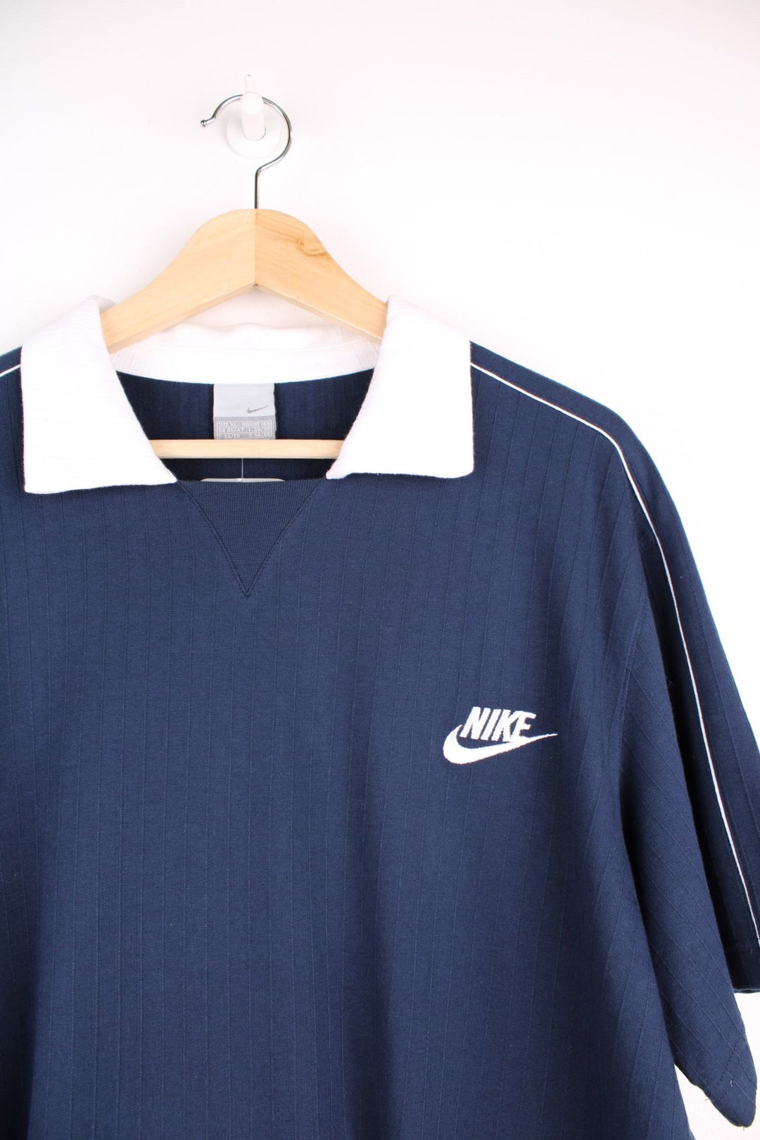 Nike polo shirt in a navy colourway with Nike logo on the front and white collar detail.