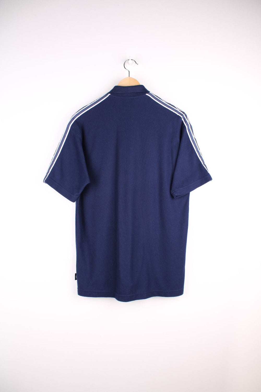 Umbro polo shirt in a navy colourway with the logo embroidered on the front and white sleeve detail.