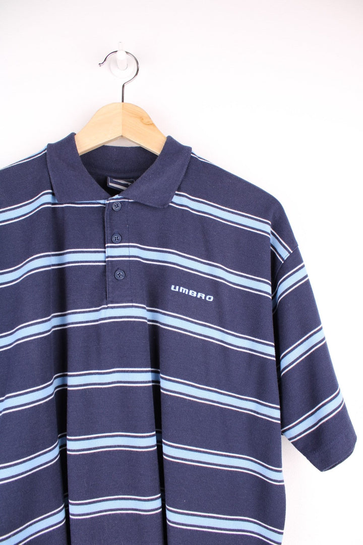 Umbro polo shirt in a striped blue and navy colourway with Umbro logo on the front.