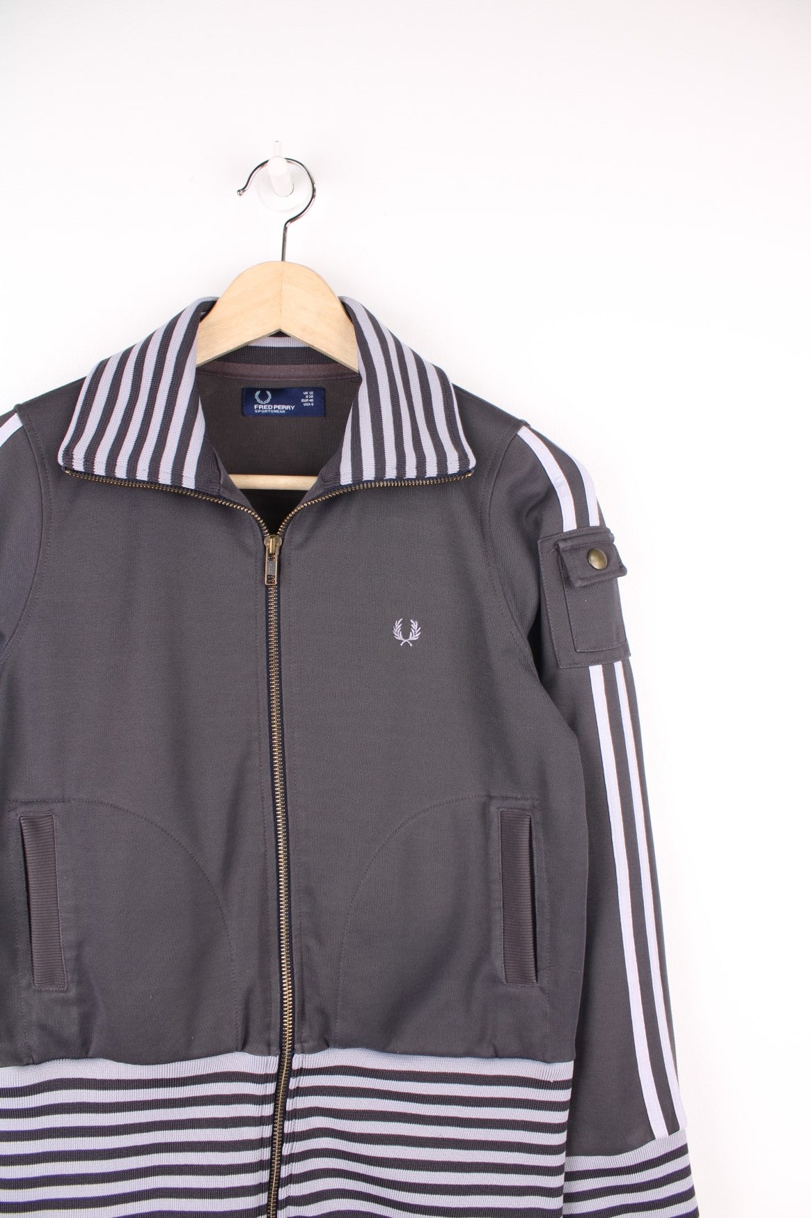 Vintage Fred Perry Tracksuit Top in a grey striped colourway, zip up with side pockets, and has the logo embroidered on the front.