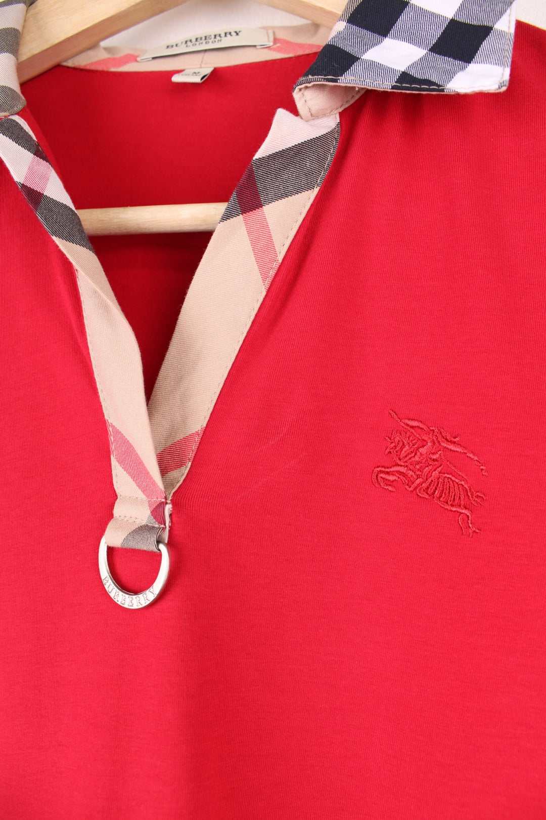 Burberry London Top in a red colourway with the nova check print on the collar and sleeves, and has the logo embroidered on the front.