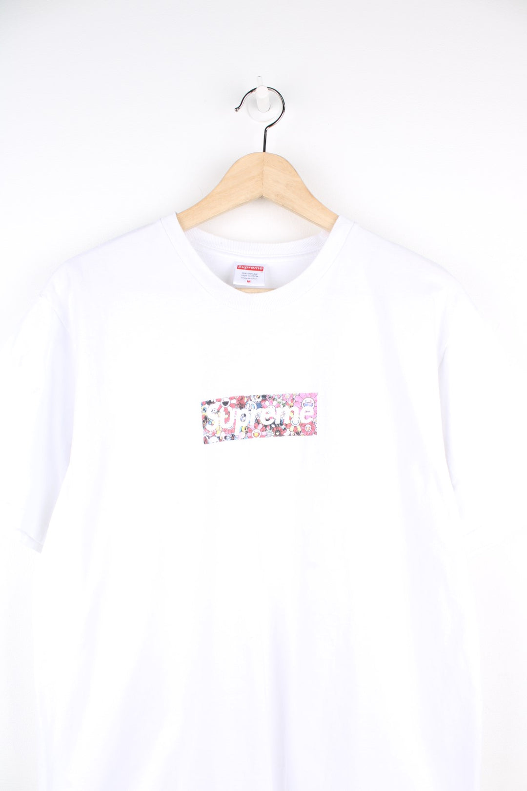 Supreme Murakami Relief Box Logo T-Shirt in a white colourway, has the supreme box logo with a floral emoji print going around, and also has 'Covid 19 Relief Fund 2020' printed on the back.