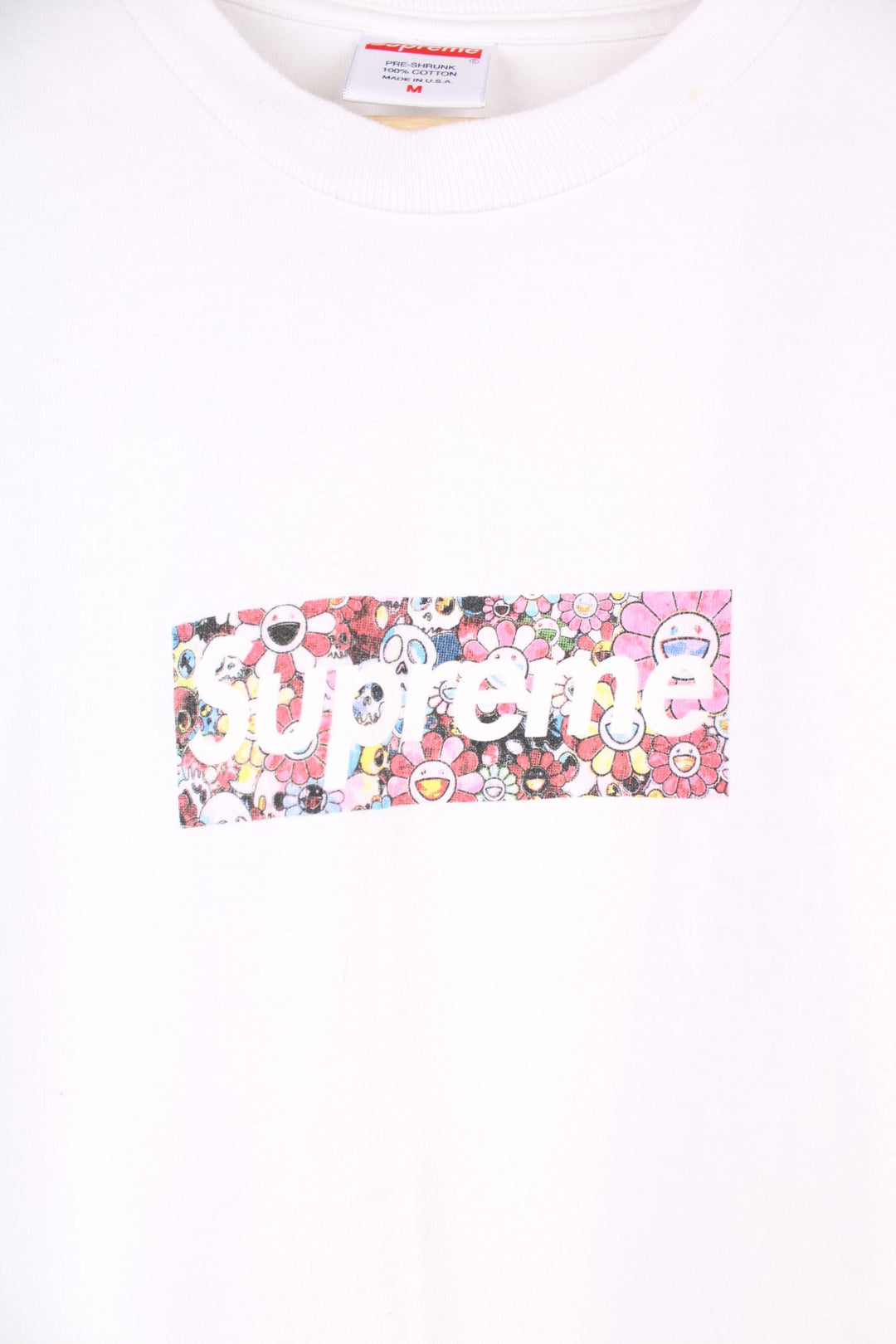 Supreme Murakami Relief Box Logo T-Shirt in a white colourway, has the supreme box logo with a floral emoji print going around, and also has 'Covid 19 Relief Fund 2020' printed on the back.